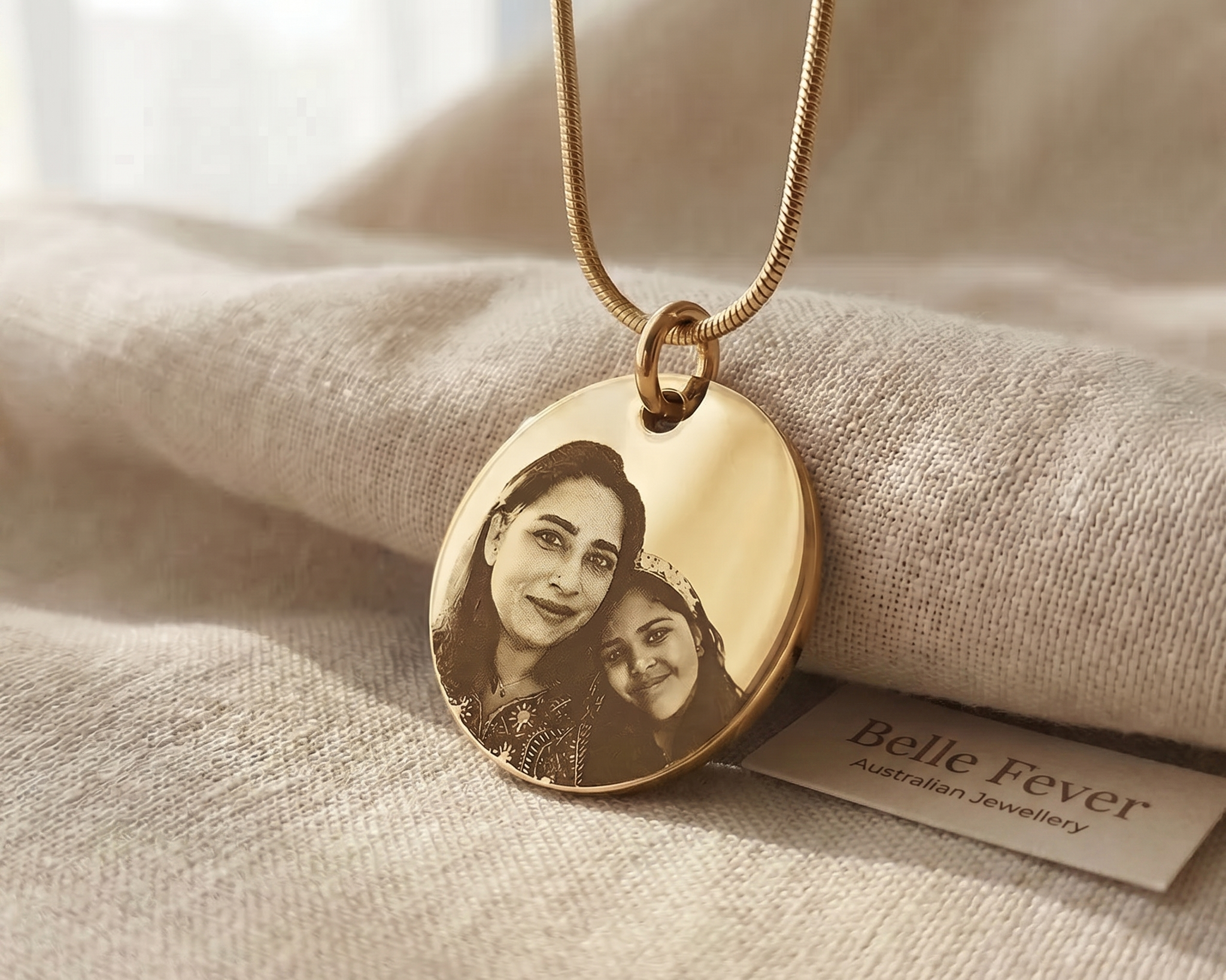 A worn engraved pendant resting on a folded linen cloth