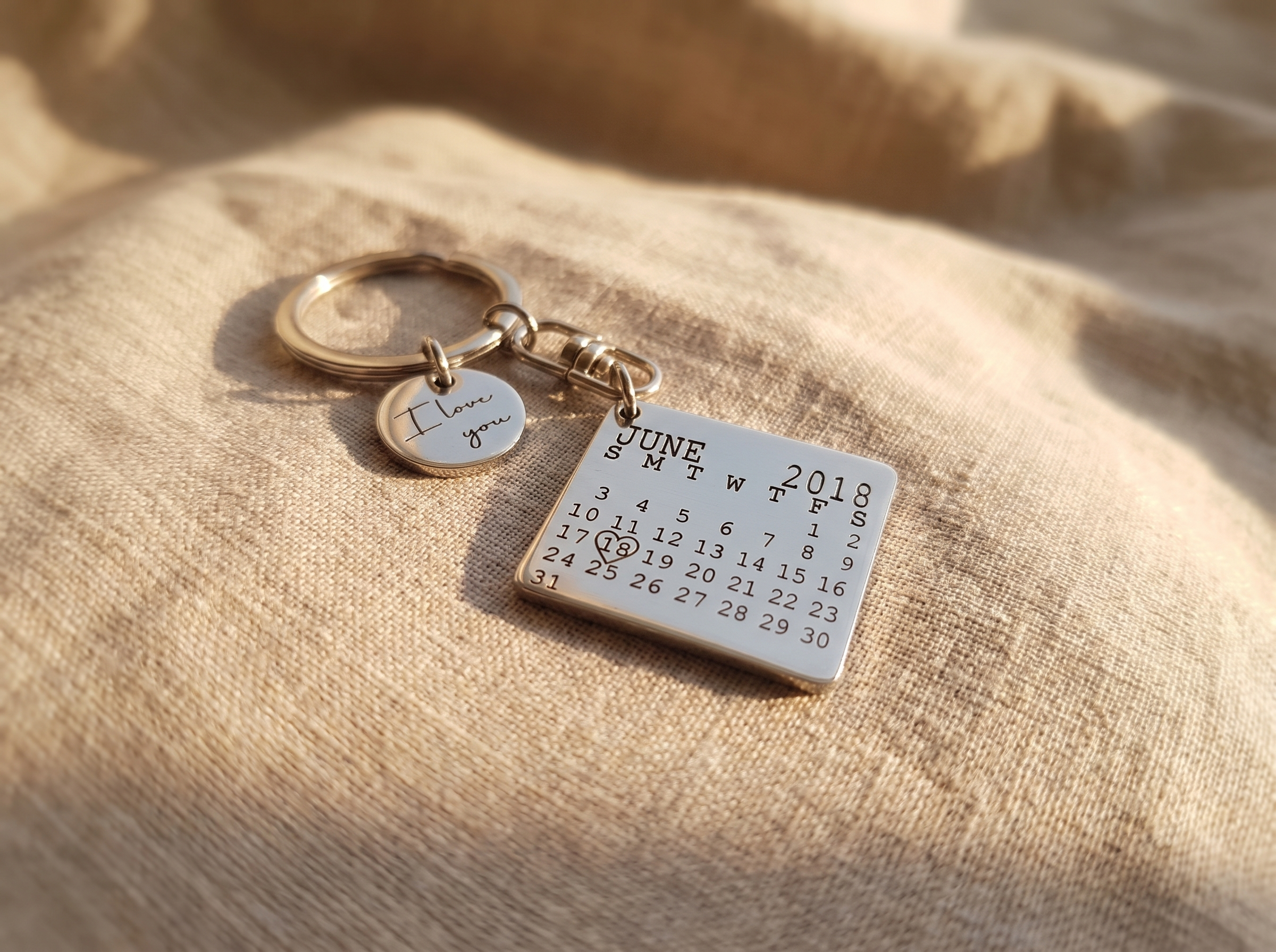 New house key with an engraved personalised keyring held in front of a front door