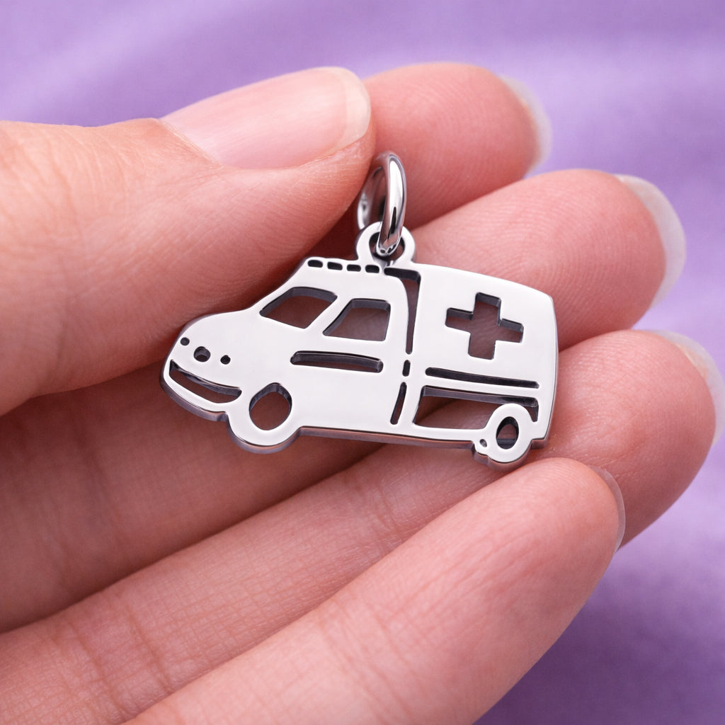 Belle Fever silver ambulance charm for keyring held between fingers, polished EMT paramedic keepsake gift.