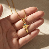 Personalized cross birthstone name necklace held in hand, meaningful Christian keepsake by belle fever