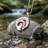 Personalized dolphin necklace by belle fever displayed on natural stone, engraved message pendant symbolizing freedom and inner strength.