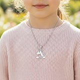 Unicorn head necklace with birthstone and engraved name worn by young girl.