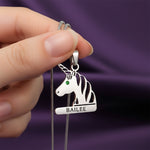 Close-up of unicorn head birthstone necklace with personalized engraved name.