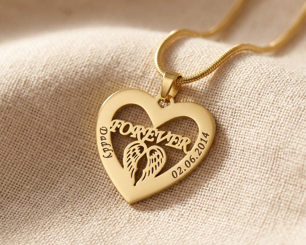 Gold Angel In My Heart necklace with heart angel wings pendant on delicate chain displayed on neutral fabric background