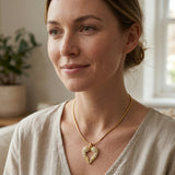 Woman wearing Angels Heart necklace with heart shaped angel wings pendant on gold chain