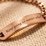 Close up of gold bar bracelet showing engraved plate detail