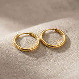 Gold chic sleeper hoop earrings with classic round hoop design displayed on neutral background