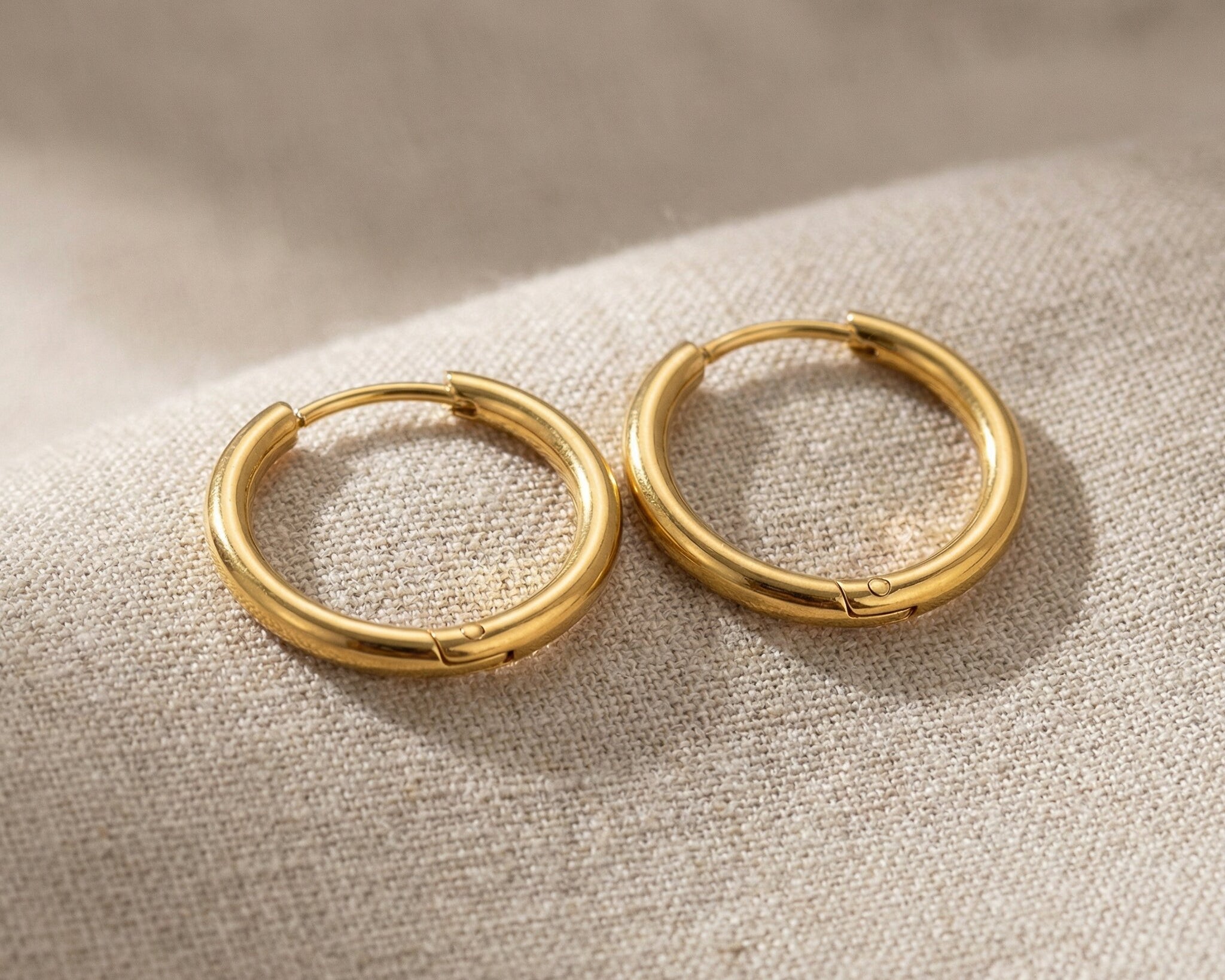 Gold chic sleeper hoop earrings with classic round hoop design displayed on neutral background