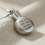 Close up of circle cremation necklace showing engraved message on round urn pendant