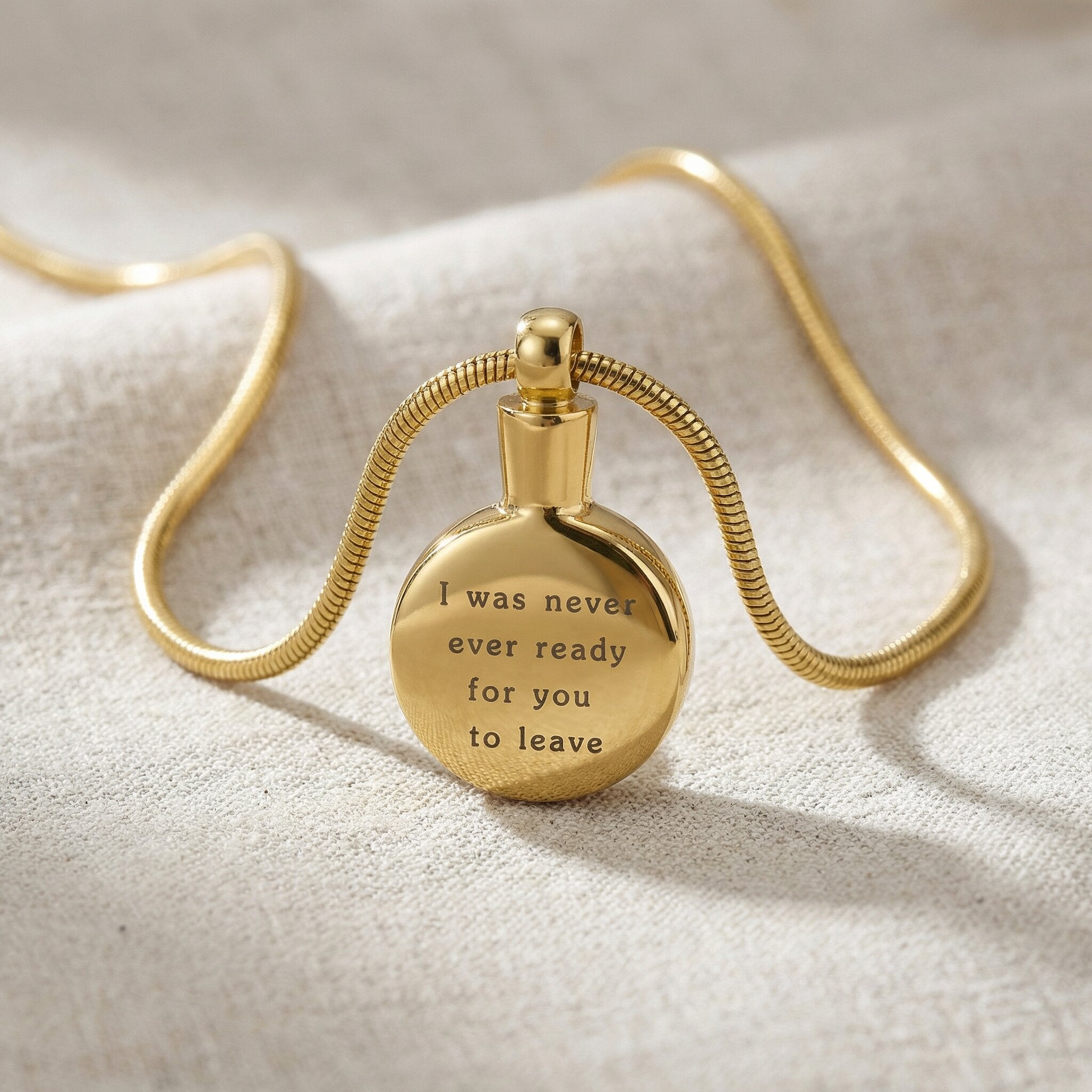 Gold circle cremation necklace with round urn pendant displayed on neutral background