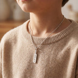 A model wearing cricket bat necklace with engraved name pendant, perfect gift for sport lover