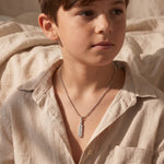 A model wearing cricket bat name necklace with engraved pendant, sporty personalised style