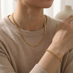 Woman wearing curb chain necklaces and bracelet, minimal flat link design