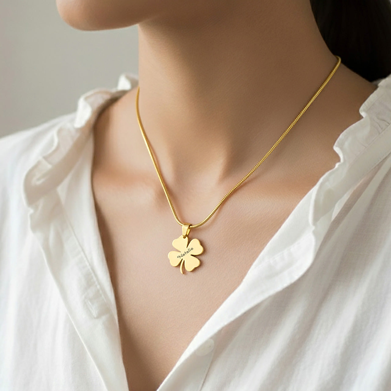 Personalized Four Leaf Clover Necklace – a woman gently wearing a gold clover pendant close to her heart. A timeless Belle Fever keepsake handcrafted with meaning.