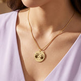 Belle Fever Hand on My Heart Necklace — gold round pendant worn close to the heart, featuring engraved handprints that symbolise comfort, love and lasting connection.