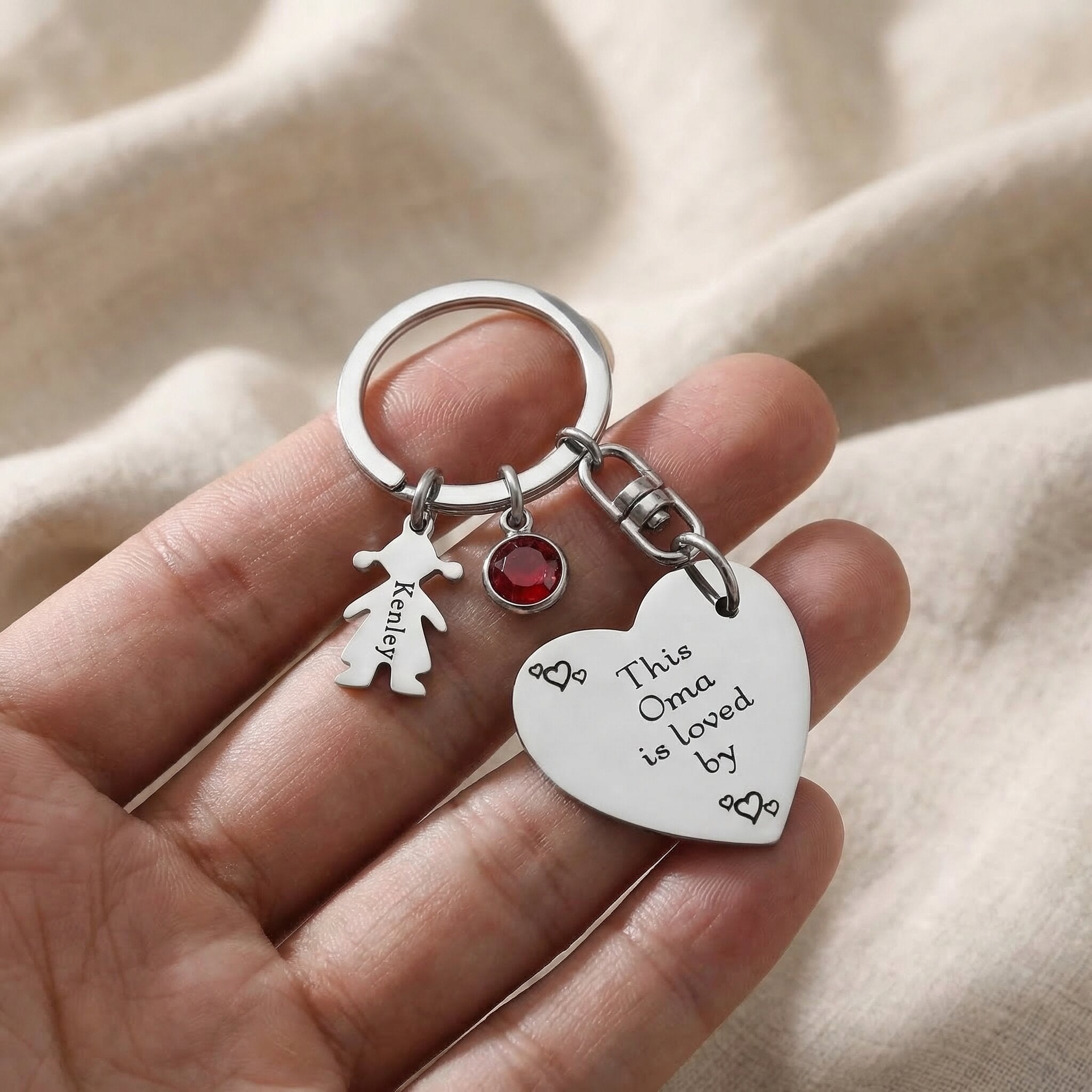 Kids Love Heart Keyring held in hand with engraved heart disc and child charm, personalised keepsake gift