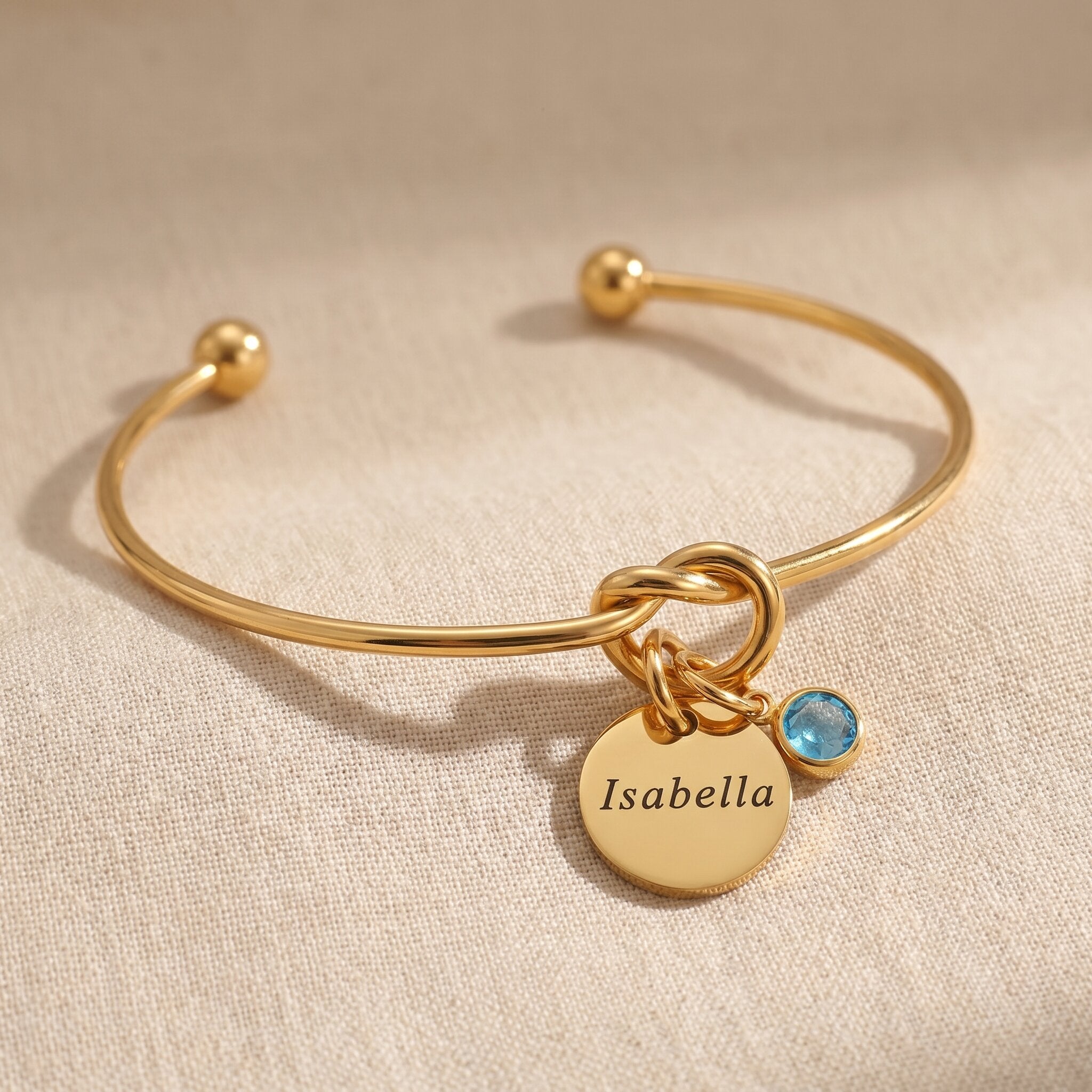 Knot bangle in gold with engraved disc and hanging stone charm, elegant keepsake gift