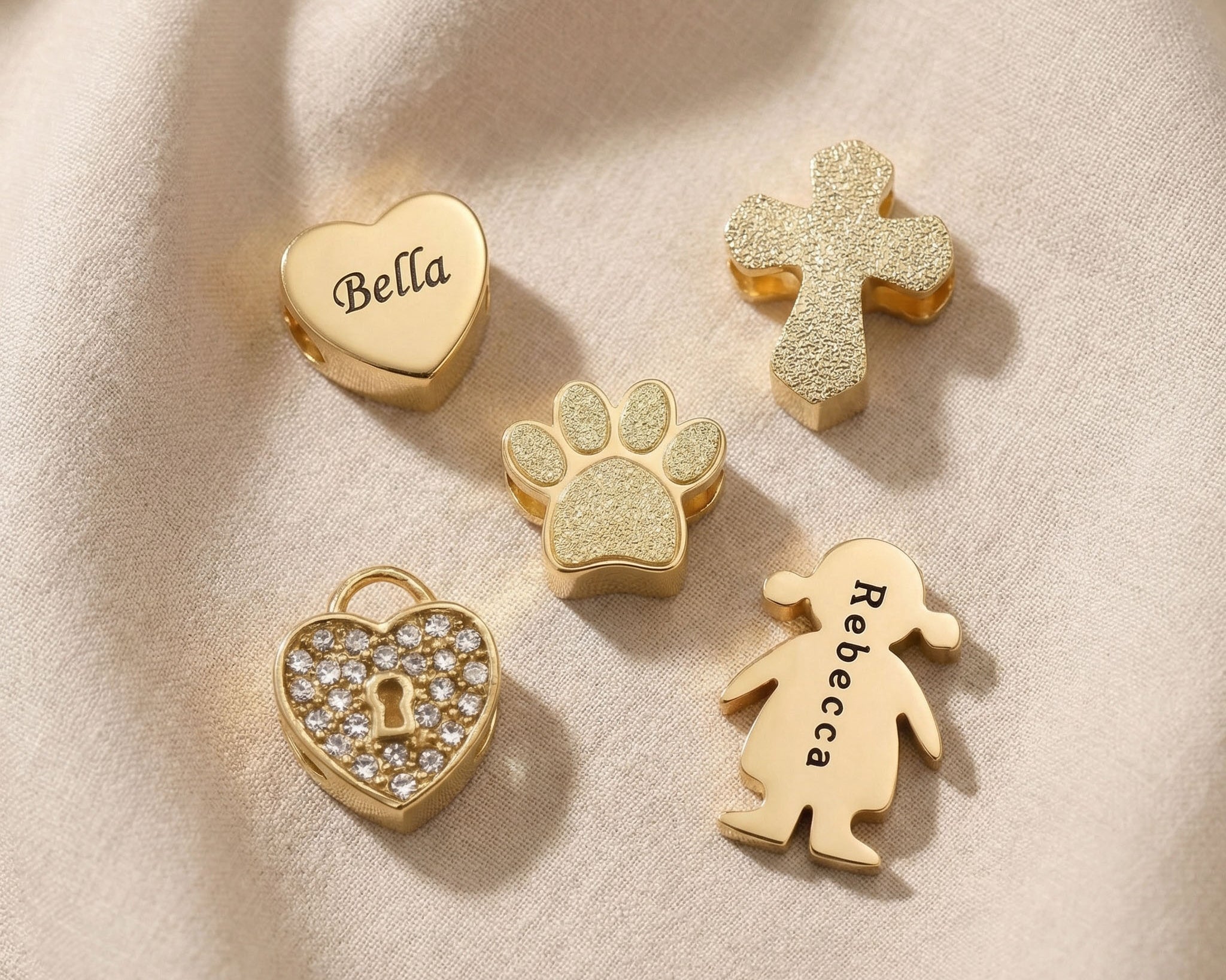 Moments charm bracelet charms in gold showing heart, cross and family symbol options