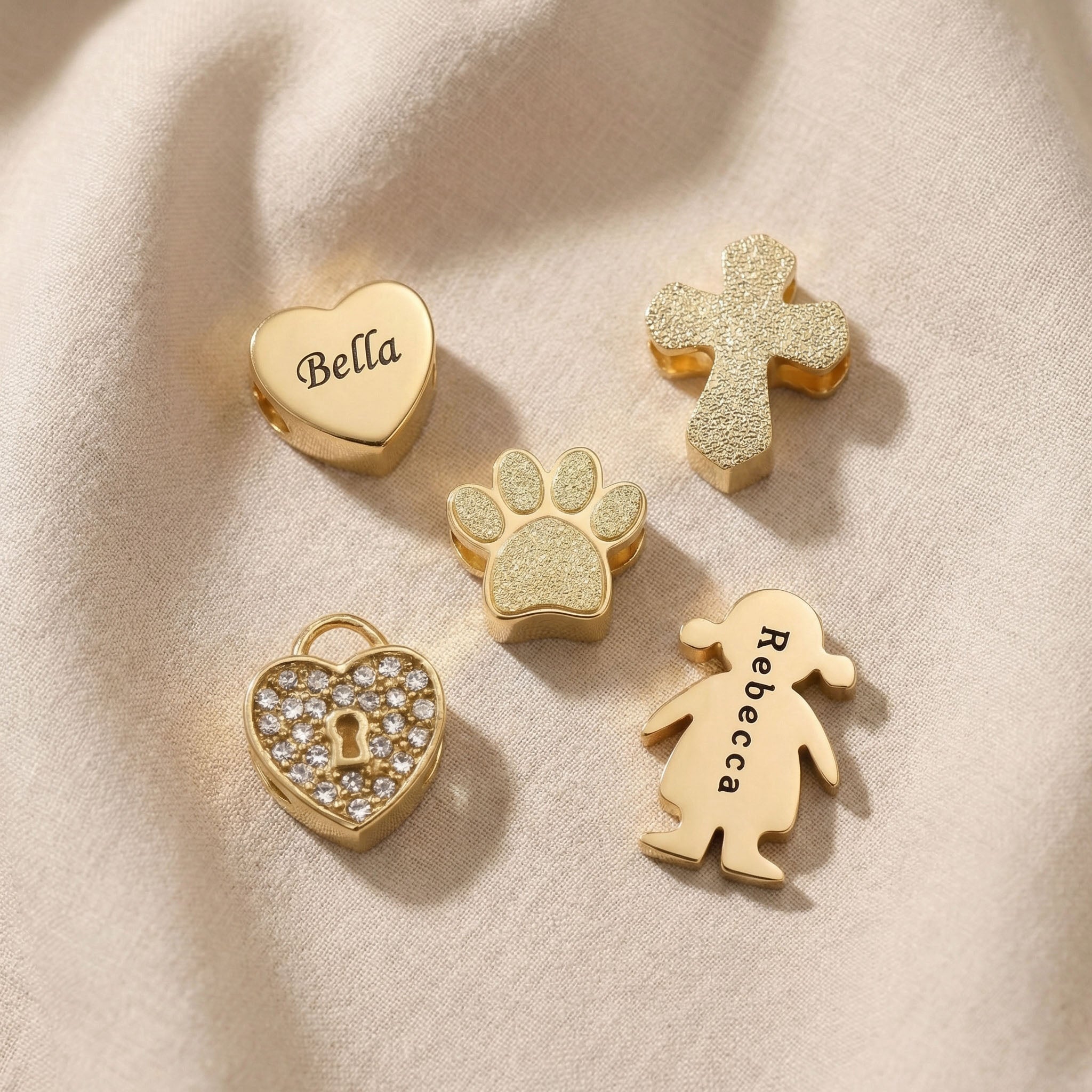 Moments charm bracelet charms in gold showing heart, cross and family symbol options