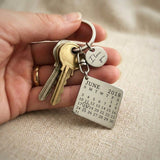Person holding personalised calendar keyring with engraved date calendar tag