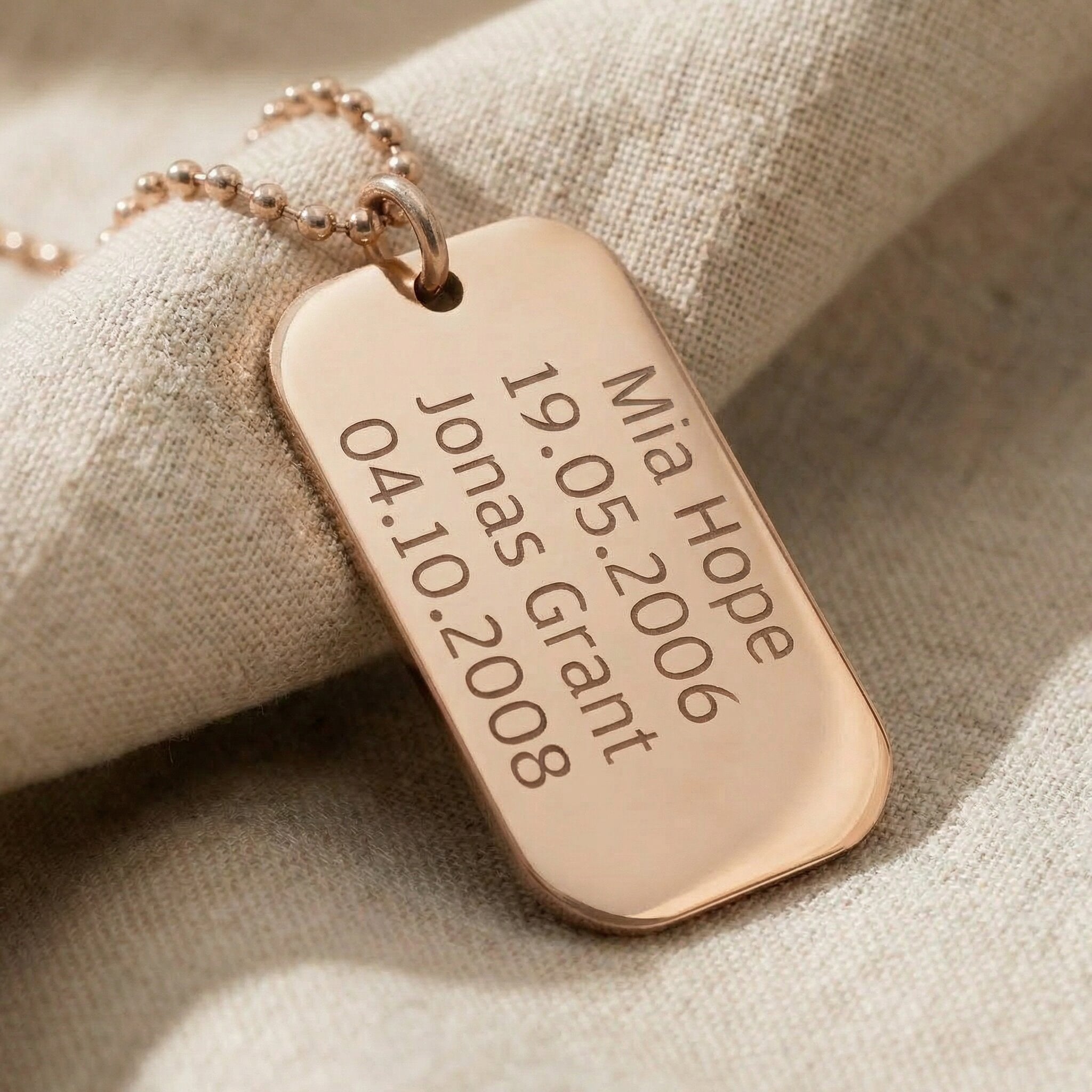Close-up of personalised dog tag necklace with engraved message showing fine detail and finish