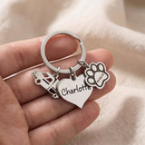 Hand holding personalised keyring charms with engraved name and decorative charm details