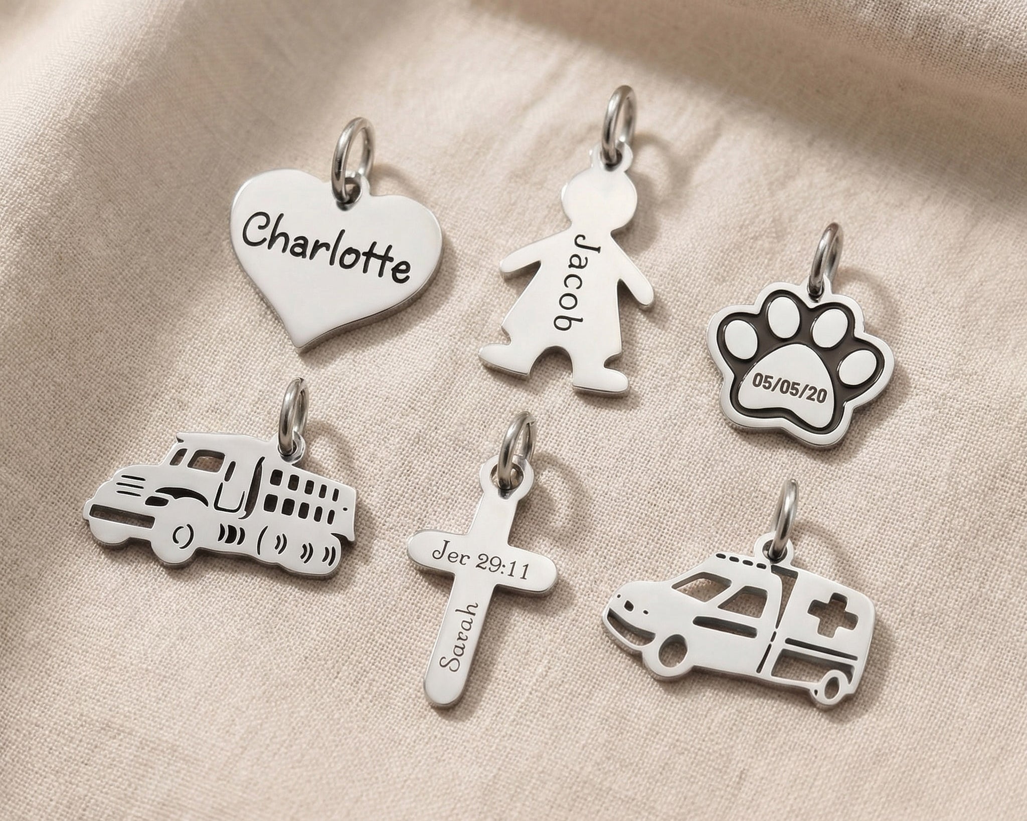 Personalised keyring charms in silver showing engraved name charms and symbol options
