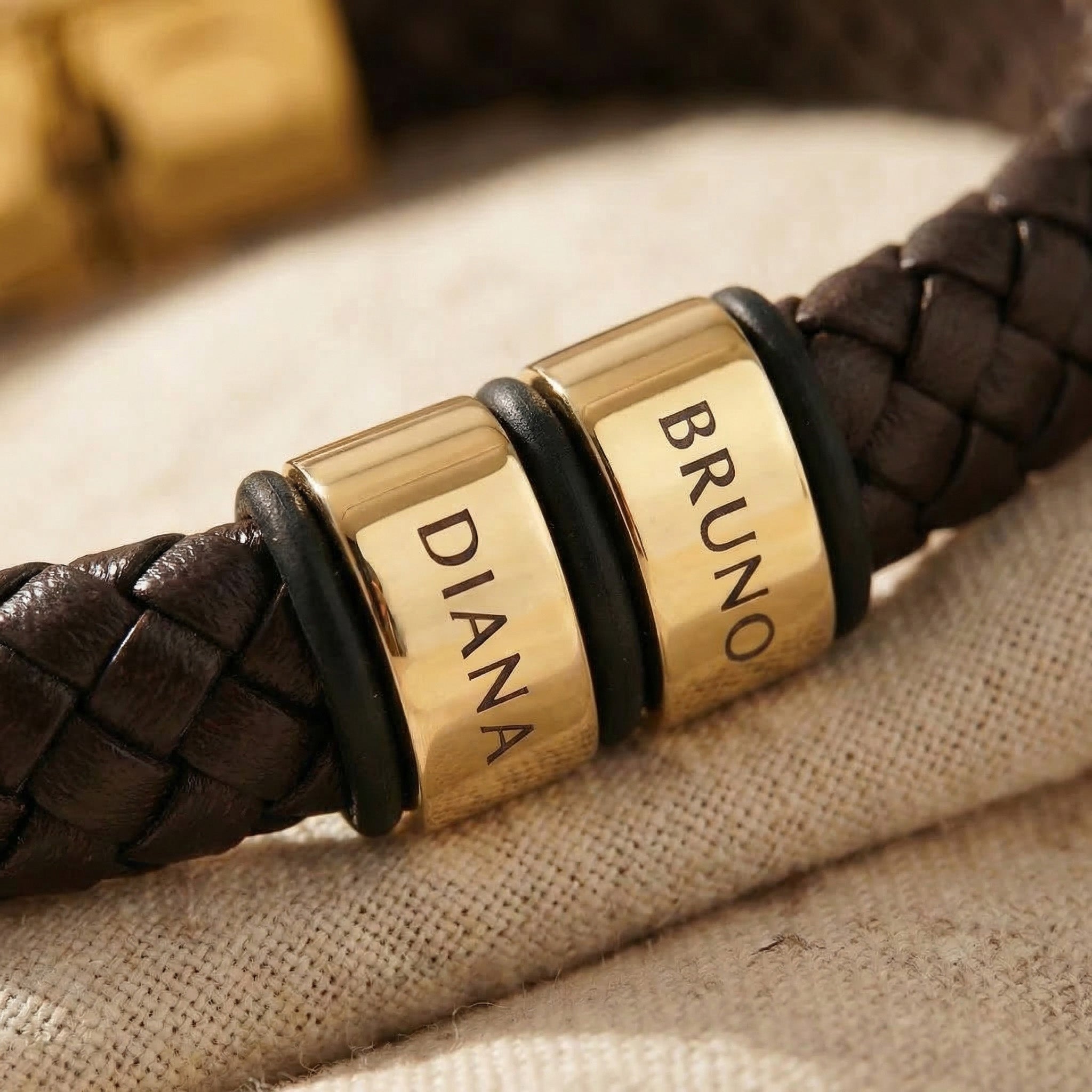 Close-up of leather bracelet charm with custom engraved name and braided leather detail