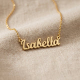 Gold personalised name necklace with script name pendant displayed on neutral background