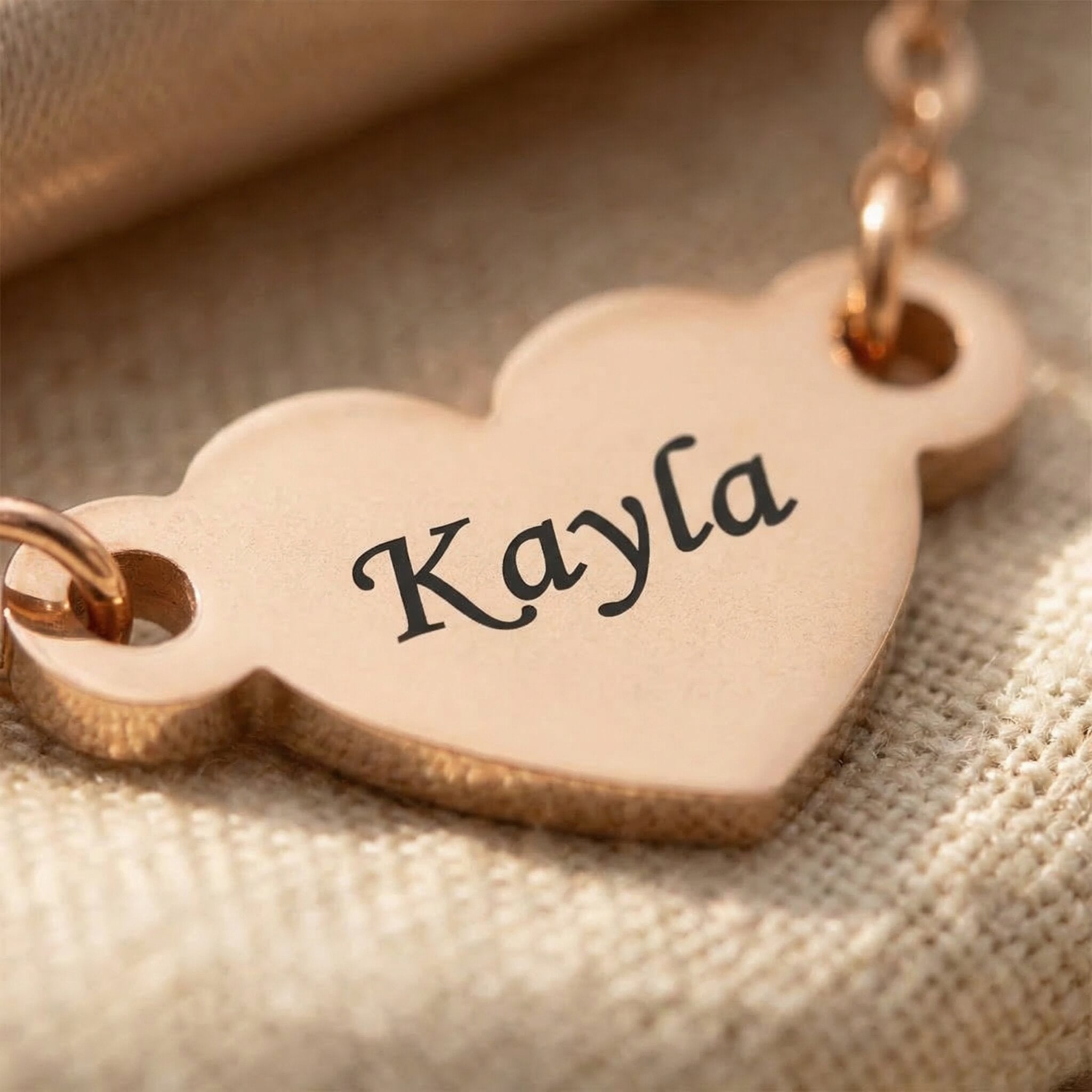 Close-up of personalised heart bracelet with engraved name on heart charm