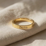 Close-up of personalised stackable ring in gold with engraved name detail