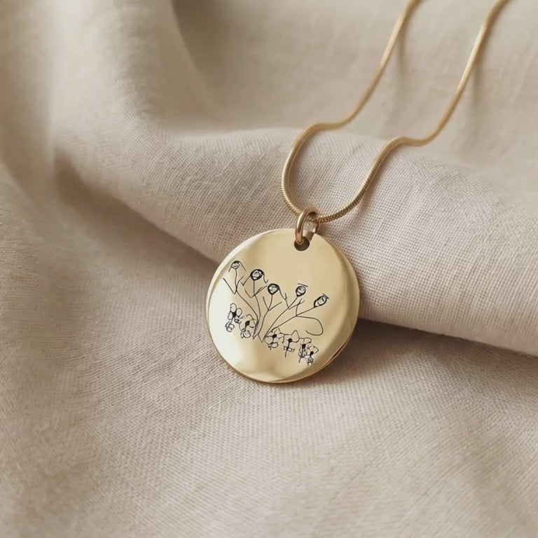 Product video showing kids drawing necklace with custom engraved artwork on pendant