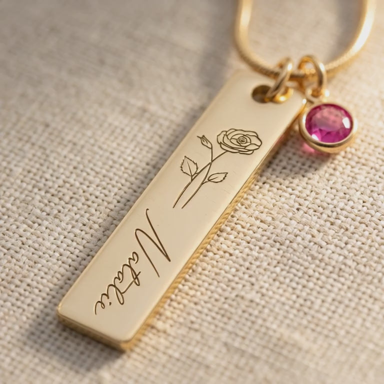 Product video showing birthflower necklace with engraved bar and birthstone charm detail