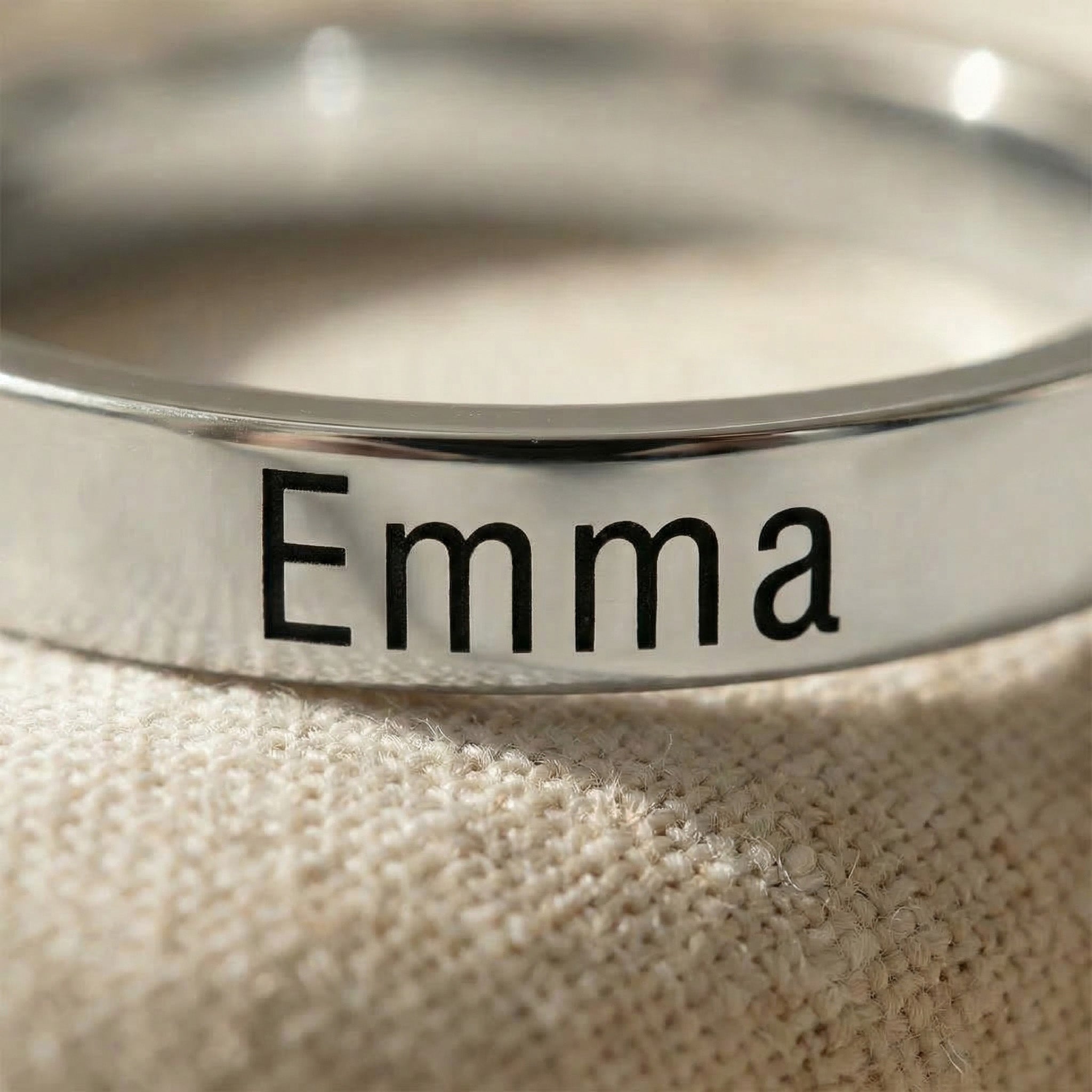 Close-up of personalised stackable ring in gold with engraved name detail